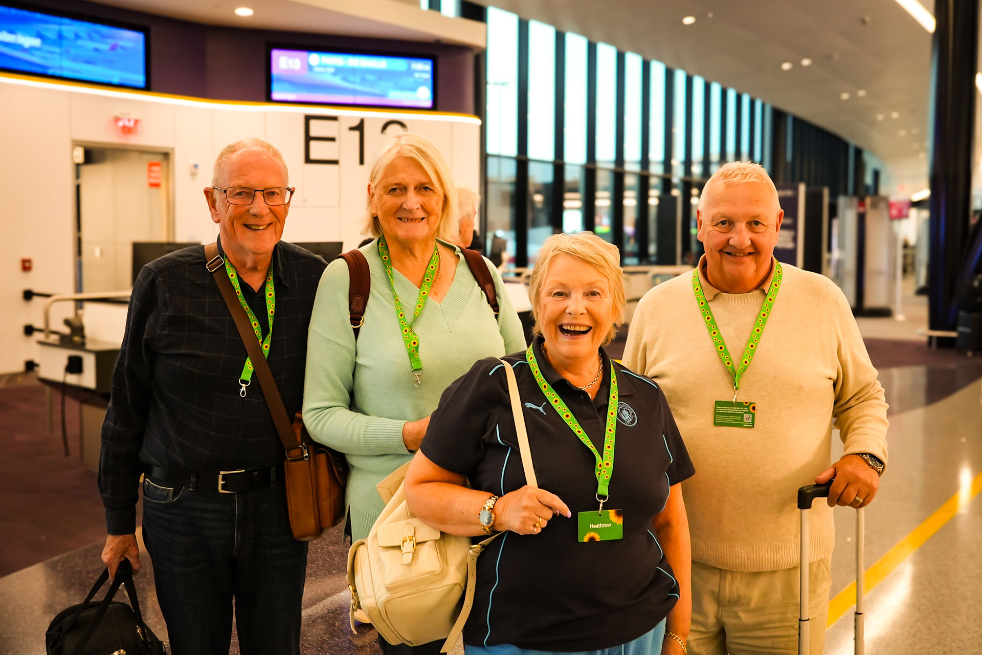 Four travelers wearing Hidden Disabilities Sunflower lanyards